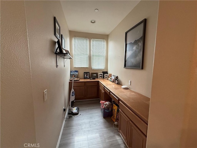 28282 Socorro St Unit 100, Murrieta, CA 92563 - bar area featuring light wood-style flooring, built in study area, and baseboards