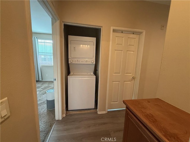 28282 Socorro St Unit 100, Murrieta, CA 92563 - clothes washing area featuring stacked washer / drying machine and dark wood-style floors
