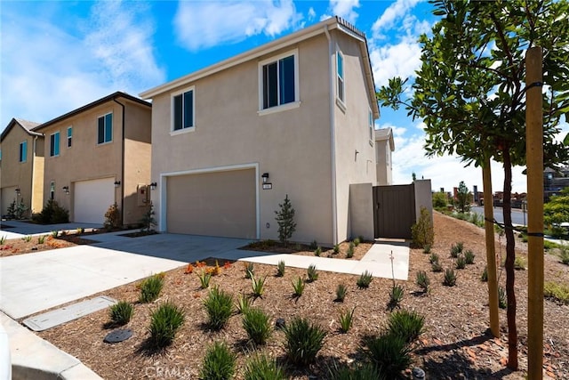 188 Merit, Irvine, CA 92618 - view of front facade featuring an attached garage, stucco siding, concrete driveway, and a gate