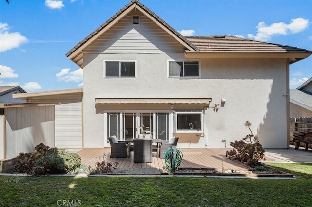 back of house with a wooden deck, stucco siding, a tiled roof, and outdoor dining space