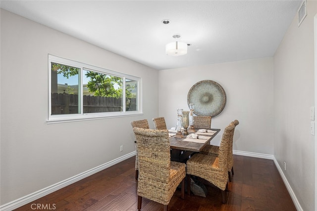 dining space with hardwood / wood-style flooring and baseboards