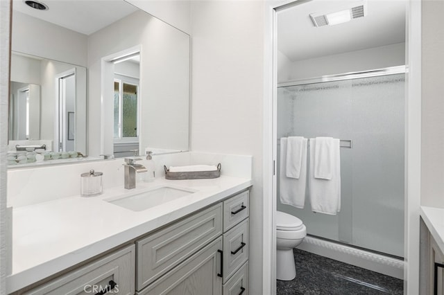 bathroom featuring toilet, vanity, and a stall shower