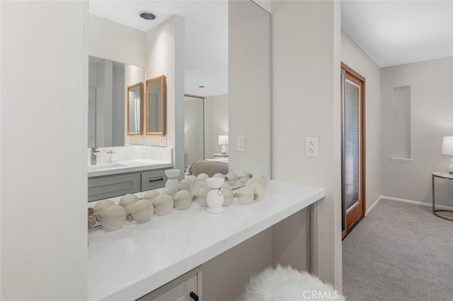 bathroom featuring vanity, connected bathroom, and baseboards