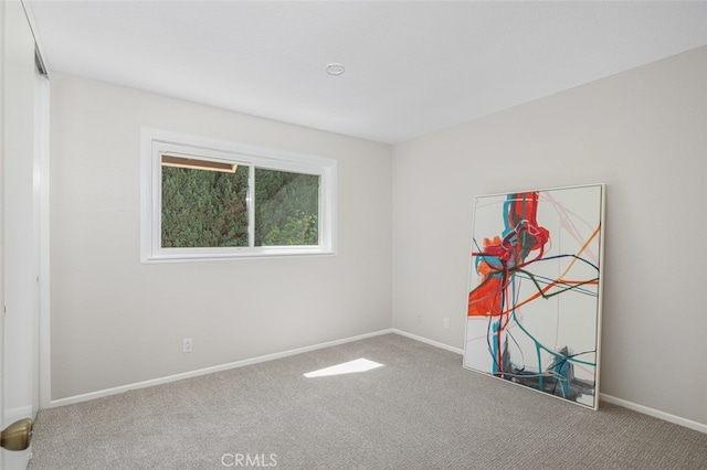 empty room featuring carpet floors and baseboards