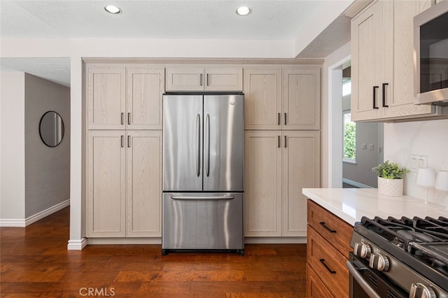 kitchen featuring appliances with stainless steel finishes, dark wood-style flooring, light countertops, baseboards, and recessed lighting