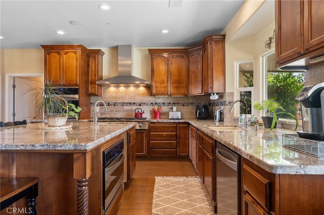 38792 Comanche Point Rd, Arvin, CA 93203 - kitchen with wall chimney exhaust hood, a sink, appliances with stainless steel finishes, light wood finished floors, and light stone counters