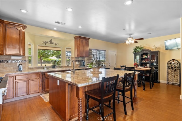 38792 Comanche Point Rd, Arvin, CA 93203 - kitchen with a sink, tasteful backsplash, light stone countertops, light wood-style floors, and recessed lighting