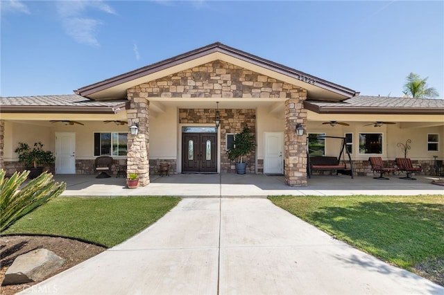38792 Comanche Point Rd, Arvin, CA 93203 - rear view of property featuring a ceiling fan, stone siding, a yard, and stucco siding