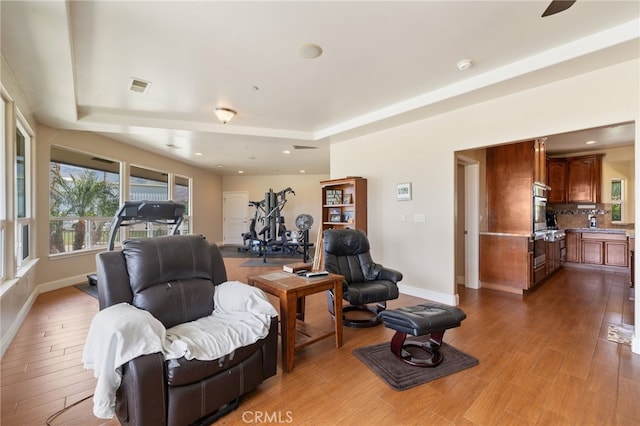 38792 Comanche Point Rd, Arvin, CA 93203 - living area featuring a tray ceiling, wood finished floors, baseboards, and recessed lighting