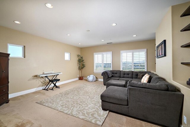 living room featuring light carpet, healthy amount of natural light, recessed lighting, and baseboards