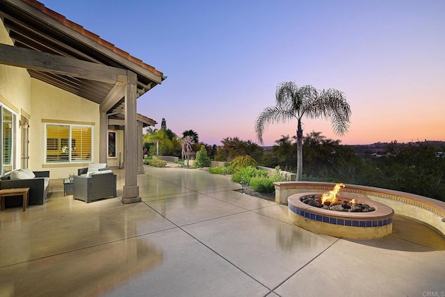 patio terrace at dusk with an outdoor living space with a fire pit
