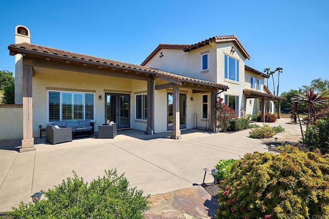 back of property with an outdoor hangout area, a patio, a tile roof, a chimney, and stucco siding