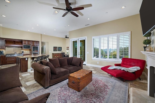 living room with a ceiling fan, recessed lighting, a high end fireplace, and french doors