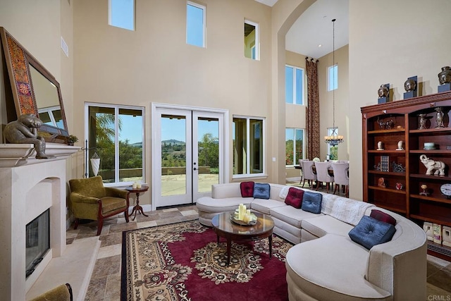 living room with a high ceiling, a high end fireplace, arched walkways, and french doors
