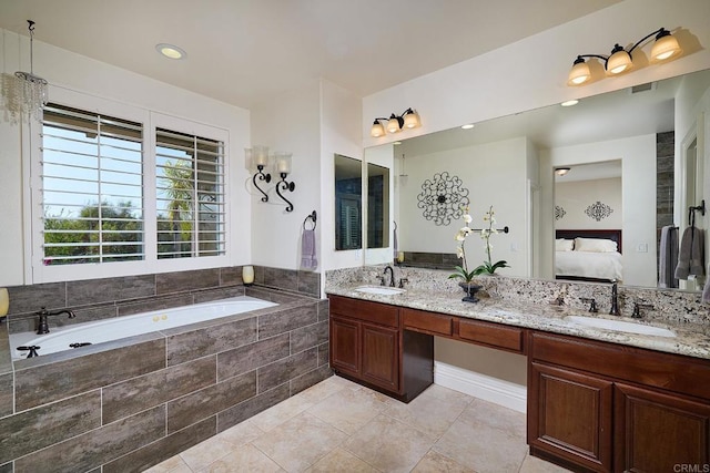 bathroom with ensuite bath, a garden tub, double vanity, and tile patterned floors