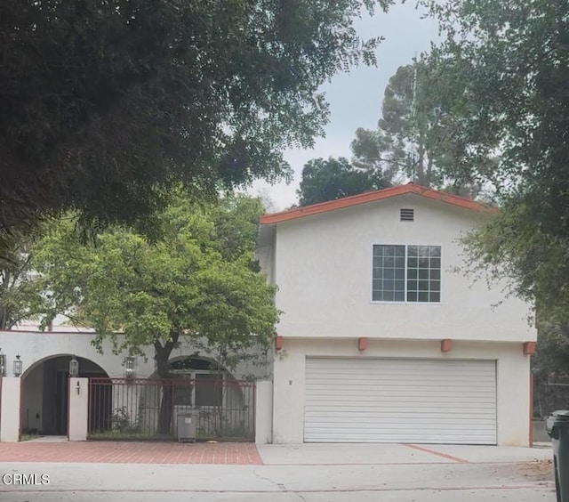 view of front facade with stucco siding, concrete driveway, and a garage