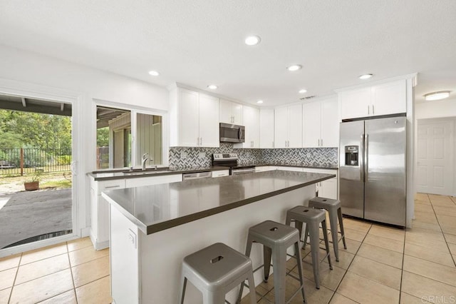 2348 Watson Way, Vista, CA 92081 - kitchen featuring appliances with stainless steel finishes, a sink, dark countertops, light tile patterned floors, and backsplash