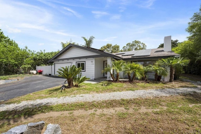 2348 Watson Way, Vista, CA 92081 - ranch-style home featuring asphalt driveway, a chimney, an attached garage, and solar panels