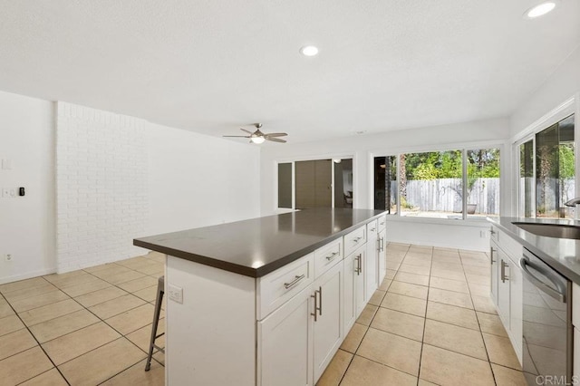 2348 Watson Way, Vista, CA 92081 - kitchen featuring stainless steel dishwasher, dark countertops, a sink, light tile patterned flooring, and a ceiling fan