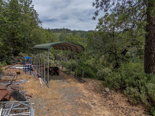 10647 Forbestown Rd, Challenge, CA 95925 - view of yard featuring a view of trees, a detached carport, and dirt driveway
