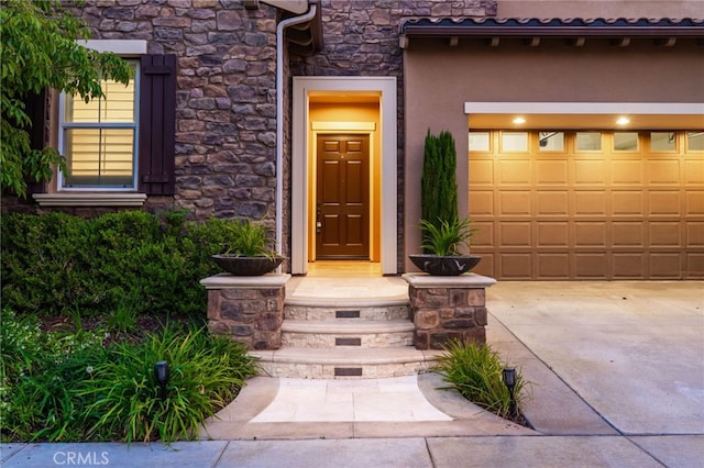 28 Dogwood, Lake Forest, CA 92630 - doorway to property with stone siding, stucco siding, driveway, and a garage