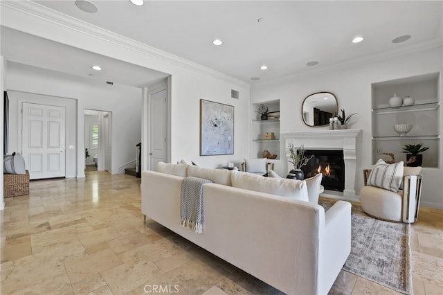 28 Dogwood, Lake Forest, CA 92630 - living area featuring built in shelves, a glass covered fireplace, crown molding, recessed lighting, and stone tile floors