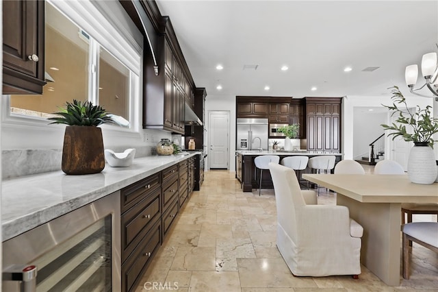 28 Dogwood, Lake Forest, CA 92630 - kitchen featuring built in fridge, stone tile flooring, beverage cooler, a breakfast bar area, and dark brown cabinets