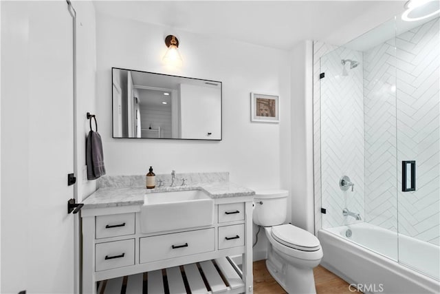 23477 Palm Dr, Calabasas, CA 91302 - full bath featuring wood finished floors, vanity, shower / bath combination with glass door, and toilet