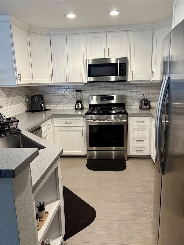 3329 E Metcalf Cir Unit B, Orange, CA 92869 - kitchen with stainless steel appliances, a sink, backsplash, white cabinetry, and recessed lighting