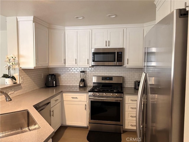 3329 E Metcalf Cir Unit B, Orange, CA 92869 - kitchen with appliances with stainless steel finishes, a sink, white cabinetry, and backsplash