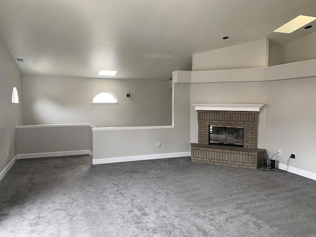 unfurnished living room featuring carpet floors, baseboards, and a brick fireplace