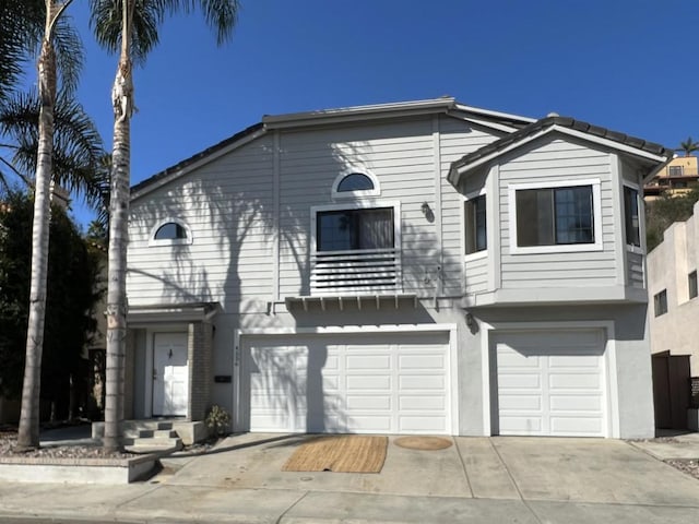 view of front of home with an attached garage, concrete driveway, and stucco siding