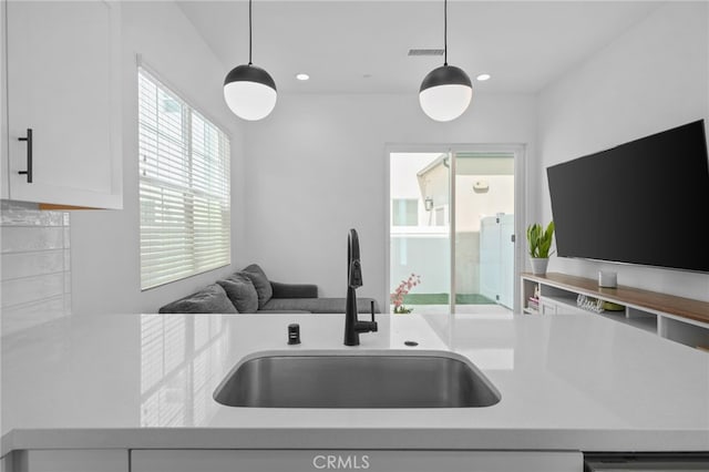 4565 S Bryant Paseo Ln, Ontario, CA 91762 - kitchen with a sink, light countertops, decorative light fixtures, white cabinets, and backsplash