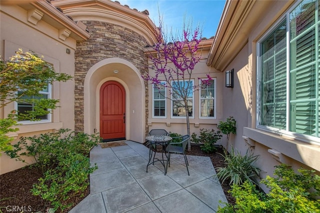 11395 N Monte Vista Way, Fresno, CA 93730 - doorway to property featuring stone siding, stucco siding, and a patio