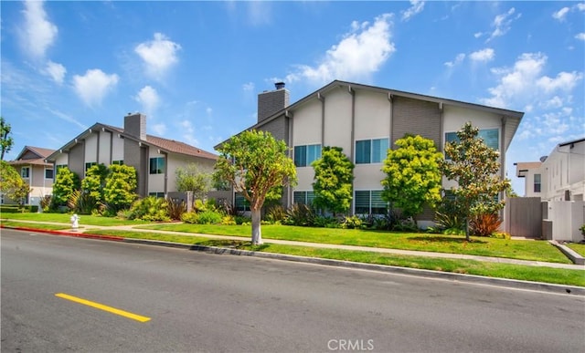 1100 Rutland Rd Unit 12, Newport Beach, CA 92660 - view of front of house featuring stucco siding and a chimney