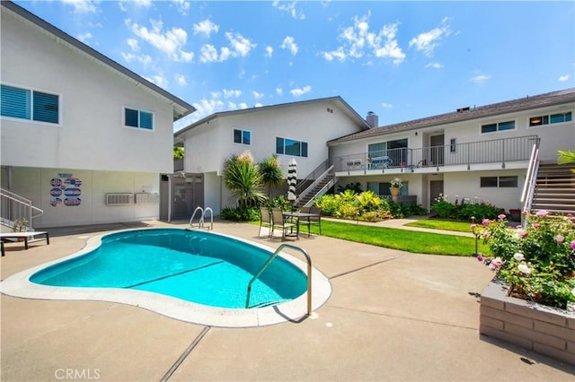 community pool with a patio and stairs