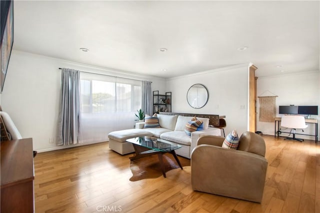 living room featuring light wood-type flooring and crown molding