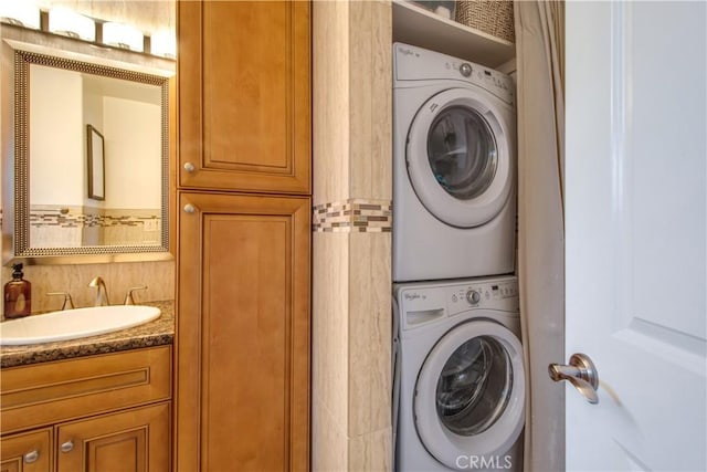 clothes washing area with stacked washer and clothes dryer