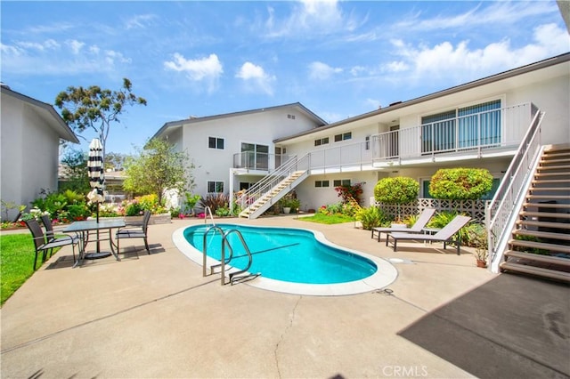 swimming pool with stairway and a patio area