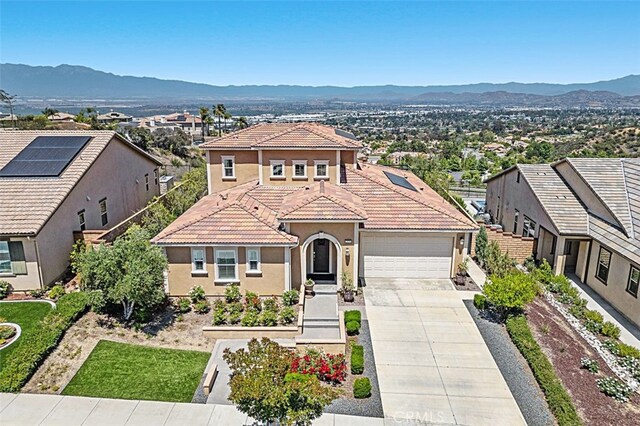 2521 Chad Zeller, Corona, CA 92882 - mediterranean / spanish-style home with concrete driveway, stucco siding, a garage, a tiled roof, and a mountain view