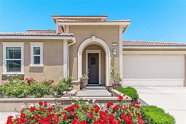 2521 Chad Zeller, Corona, CA 92882 - view of exterior entry featuring stucco siding, concrete driveway, an attached garage, and a tile roof