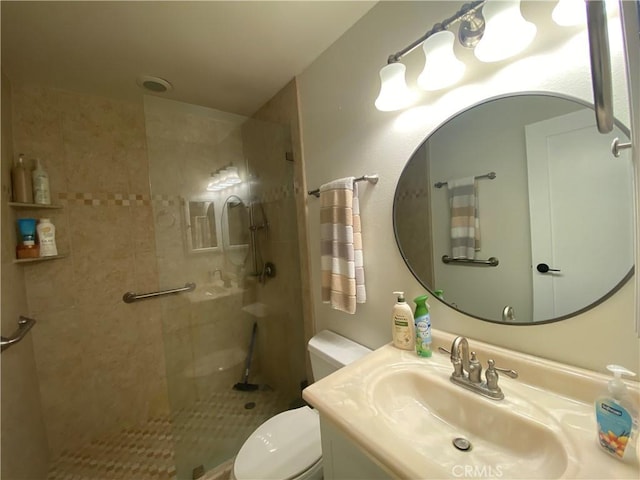 full bathroom featuring toilet, a tile shower, and vanity