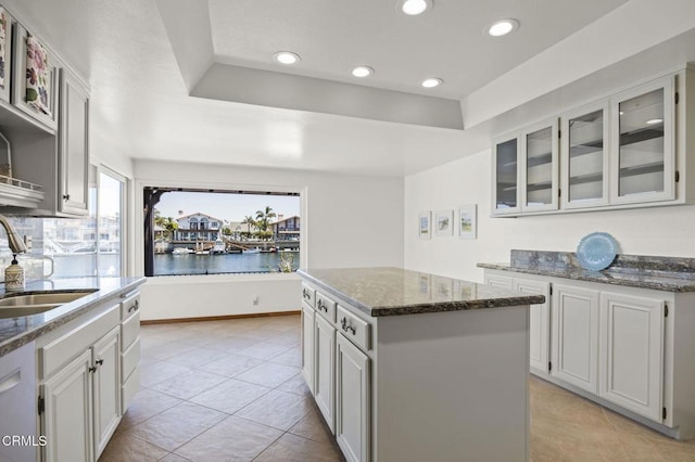 2120 Jamestown Way, Oxnard, CA 93035 - kitchen featuring a sink, a kitchen island, dark stone counters, glass insert cabinets, and recessed lighting