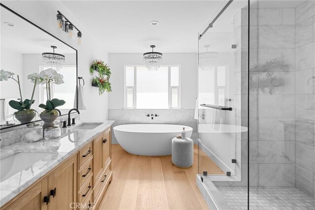 1804 Deer Canyon Rd, Arroyo Grande, CA 93420 - bathroom featuring wood finished floors, a stall shower, double vanity, a soaking tub, and a chandelier