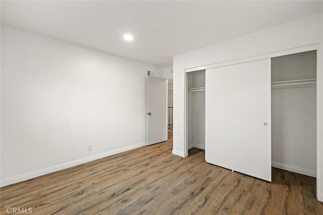 128 Fairview St Unit 1, Santa Ana, CA 92704 - unfurnished bedroom featuring wood finished floors, a closet, recessed lighting, and baseboards