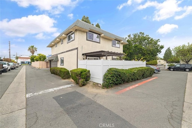 128 Fairview St Unit 1, Santa Ana, CA 92704 - view of home's exterior with fence, uncovered parking, and stucco siding
