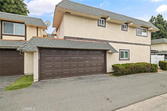 128 Fairview St Unit 1, Santa Ana, CA 92704 - townhome / multi-family property with stucco siding, mansard roof, and a garage