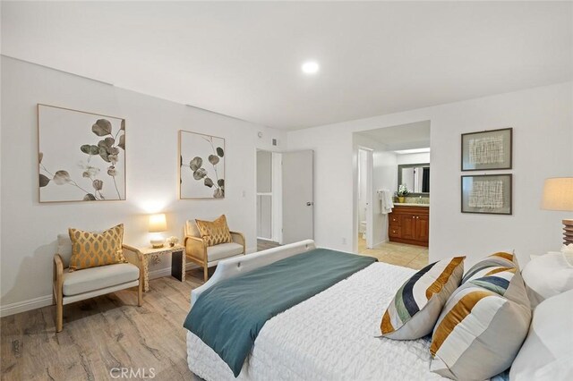 128 Fairview St Unit 1, Santa Ana, CA 92704 - bedroom with light wood-style flooring, baseboards, and ensuite bathroom