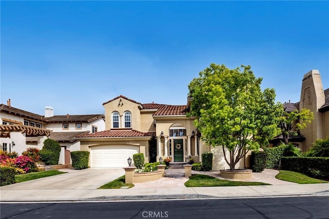 view of front of house featuring driveway, stucco siding, a tile roof, and an attached garage