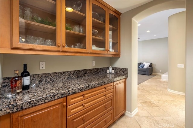 bar featuring arched walkways, light tile patterned floors, baseboards, and recessed lighting